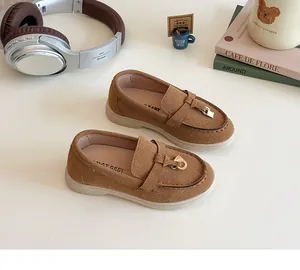 Close-up of brown suede children's loafers with metal buckle and soft slip-resistant sole