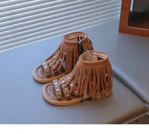 Détail de sandales bohèmes à franges pour filles avec clous et fermeture éclair latérale