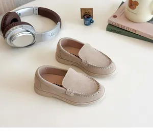 Dettaglio mocassini beige per bambini in pelle scamosciata con suole spesse