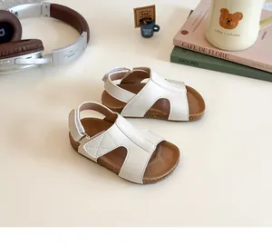 Close-up of girls' white cutout sandals with soft cork soles and velcro straps for kids