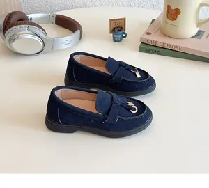 Macro detail of navy blue suede children's loafers with elegant golden circular charms