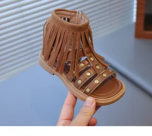 Détail de sandales brunes pour filles avec franges bohèmes et rivets en métal