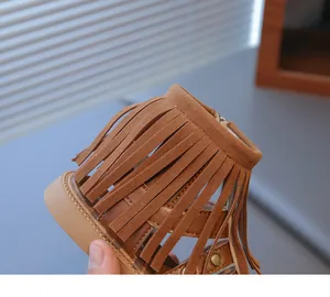 Détail de sandales marron à franges pour filles avec design pompon et style bohème
