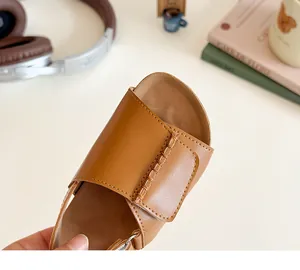 Detailed close-up of brown girls' sandals featuring woven texture and ergonomic footbed