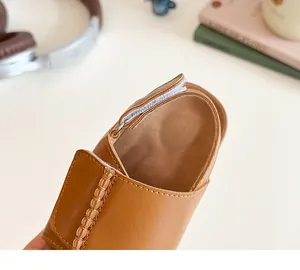 Detail of brown leather girls' sandals with velcro strap and white stitching