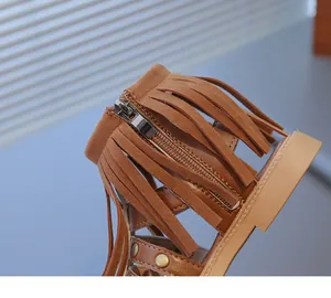 Vue détaillée des sandales bohèmes pour enfants avec franges, zip et rivets dorés