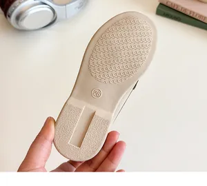Detailed view of beige non-slip rubber sole with size 28 marking on toddler loafer shoes