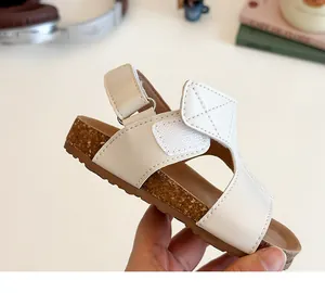 Detail of off-white girls' sandal showing soft cork texture sole and hook and loop strap