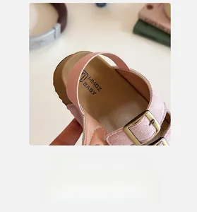 Détail de sandales roses pour bébé avec doublure douce et boucle métallique réglable