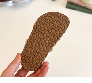 Close-up of girls' sandals showing anti-slip brown rubber sole with size 23 detail