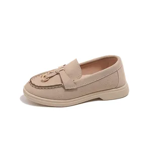 Minimalist khaki suede children loafers with golden metal ring buckle on white background