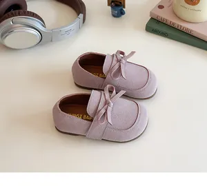 Close-up of pink suede girls' princess shoes with sweet bow detail and soft texture