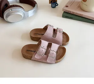 Detail of pink suede children sandals with metal buckles and cork textured midsole