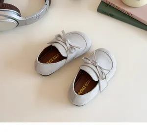 Detail view of beige suede kids loafers with bow and soft cushioned inner sole