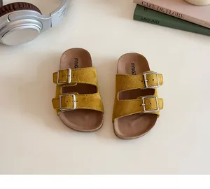 Detail of mustard yellow suede straps and silver buckles on ergonomic cork sandals