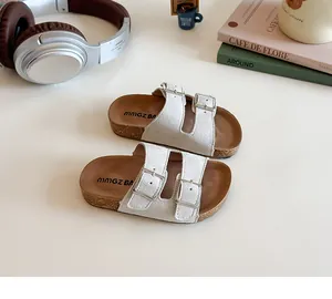 Detail of kids cork slide sandals featuring white adjustable buckles and ergonomic footbed