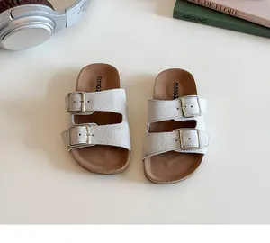 Detail of kids double-strap suede sandals with adjustable metal buckles and cork footbed