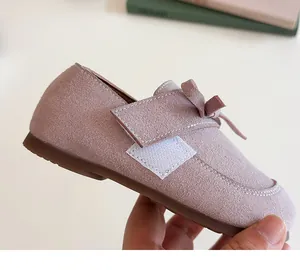 Close-up of pink suede toddler shoes featuring a cute bow and velcro strap