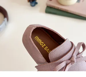 Detail view of pink suede girl shoes with bow accent and branded golden logo insole