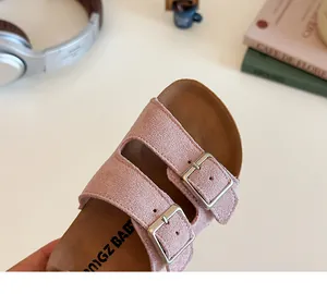 Detail view of pink suede kids sandals with cork footbed and dual silver buckles