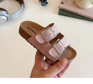 Detailed view of pink kids double buckle slide sandals with cork sole and suede texture