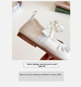 Détail de babies crème pour filles avec nœud en soie, perle et fermeture velcro