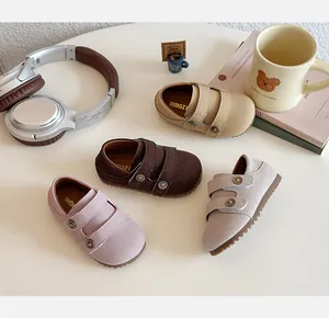Dettaglio di quattro scarpe Birkenstock per bambini nei colori rosa, caffè, sabbia e grigio