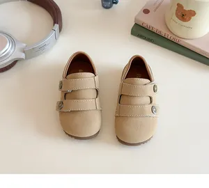 Dettaglio di scarpe in camoscio kaki per bambine con doppio cinturino a strappo e fibbie
