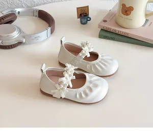 Détail de chaussure Mary Jane crème avec nœud en perles et semelle antidérapante