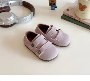 Dettaglio di scarpe rosa scamosciate da bambina con chiusura a strappo e suola morbida