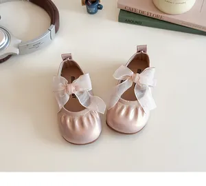 Detailed top view of light pink girls' princess shoes with elegant organza bow accents