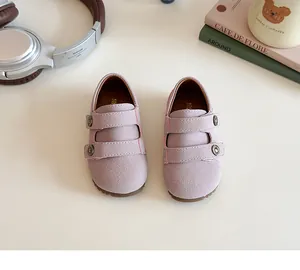 Dettaglio di scarpe in camoscio viola per bambina con velcro e fibbie in metallo rétro