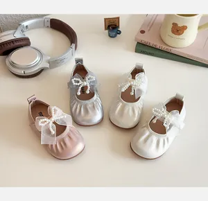 Flat lay of girl's pearl bow princess shoes in pink, silver, and cream white colors