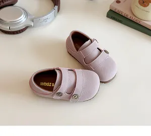 Dettaglio di scarpe primi passi in camoscio rosa con doppia chiusura a strappo in velcro