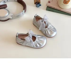Detail of silver girls' flat shoes with mesh bow and elasticated trim on light background