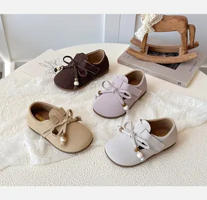Detail of four pairs of soft-soled girls' Mary Jane shoes with bows and wooden beads