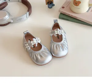Détail de chaussures Mary Jane argentées avec nœuds en perles et accessoires