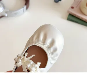 Détail de chaussures Mary Jane blanches pour filles avec nœud perlé et plis doux