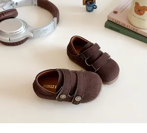 Dettaglio ravvicinato di scarpe da bambino in camoscio marrone con doppia chiusura velcro