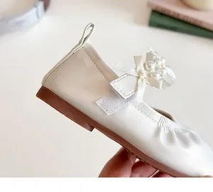 Détail de chaussures Mary Jane beiges pour filles avec nœud en perles et semelle en gomme