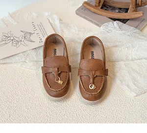 Detailaufnahme brauner Mädchen-Loafer mit goldener Schnalle und weicher beiger Sohle