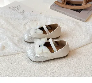 Detail of girls' cream princess shoes with sequin toe, mesh bow, and rhinestone charm