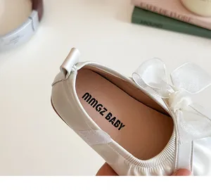 Detail of white girls princess shoes with large organza bow and elastic collar