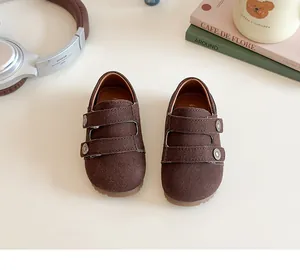 Dettaglio di scarpe retrò per bambini marrone scuro con cinturini e suole in gomma