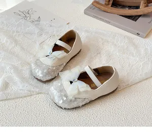 Detail of cream Mary Jane shoe for girls with silver sequins and rhinestone bow decoration