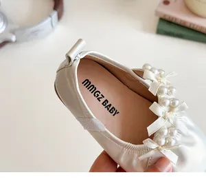 Détail de chaussures de princesse crème pour filles avec nœud en perles élégant