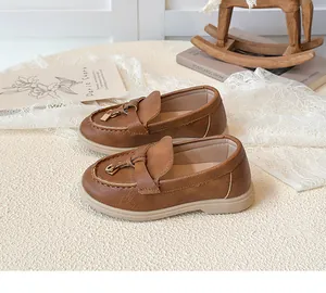 Detailansicht der braunen Mädchen-Loafer mit Schleifenakzent und goldenem Schloss