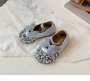 Detailed view of silver sequined Mary Jane shoes with mesh bow and teardrop rhinestone