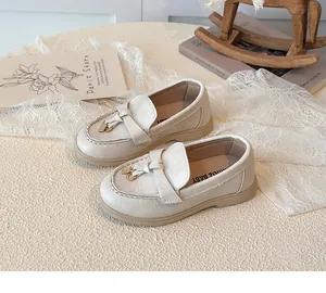 Detailansicht cremefarbener Mädchen-Loafer mit Fransen, Gold-Schnalle und Gummisohle