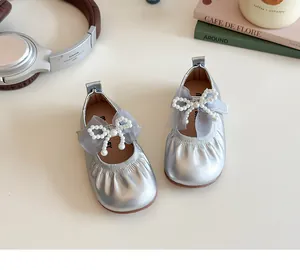 Close-up of silver Mary Jane shoes with tulle bow and white pearl detailing